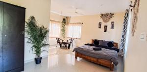 a bedroom with a bed and a potted plant at Ghar - Homestay, Where Family Lives Together in Aruvankadu