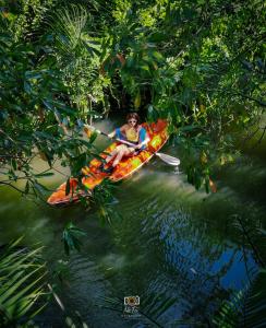 a woman is riding a kayak in a river at Nary Garden in Kampot