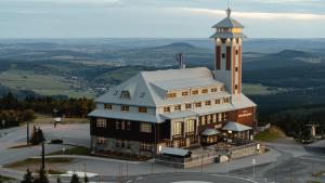 ein großes Gebäude mit einem Uhrturm darüber in der Unterkunft Fichtelberghaus in Kurort Oberwiesenthal