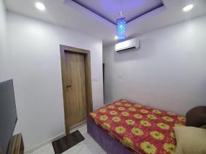 Habitación con cama con manta roja y puerta en Dinero Rose-2 Bedroom Apartment, en Lagos