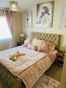 a bedroom with a large bed with a stuffed animal on it at Highfields Holiday Park Clacton in Clacton-on-Sea