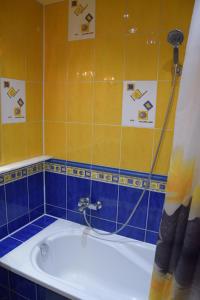 a bath tub in a bathroom with blue and yellow tiles at Apartament Julia 1-6 os II piętro in Kielce