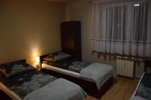 a room with two beds and a window with at Apartament Julia 1-6 os II piętro in Kielce