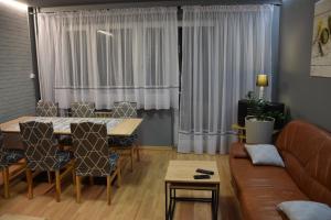 uma sala de estar com uma mesa e um sofá em Apartament Julia 1-6 os II piętro em Kielce