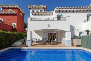 eine Villa mit einem Pool und einem Haus in der Unterkunft Mar Menor Golf Resort - 526 in Las Casicas
