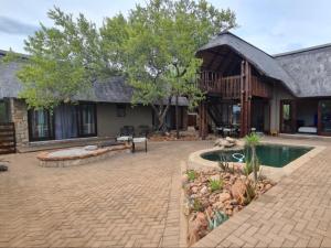 a house with a patio and a swimming pool at Hoedspruit Bush Stay in Hoedspruit