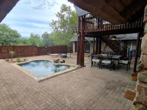 a patio with a pool and a table and chairs at Hoedspruit Bush Stay in Hoedspruit