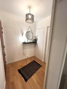 a hallway with a mirror and a rug at La Coulée Verte - Vue dégagée in Reims