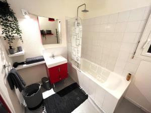 a bathroom with a sink and a red cabinet at La Coulée Verte - Vue dégagée in Reims