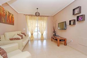 ein Wohnzimmer mit einem Sofa und einem TV in der Unterkunft Mar Menor Golf Resort - 526 in Las Casicas