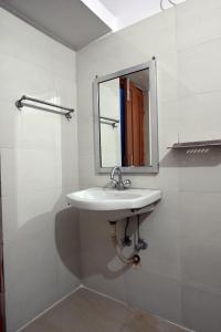 a bathroom with a sink and a mirror at The Clovers Inn Boring Road in Patna