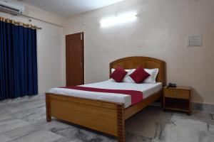 1 dormitorio con 1 cama grande con almohadas rojas en The Clovers Inn Boring Road, en Patna