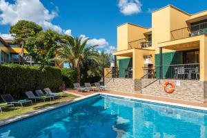 a swimming pool in front of a villa at Apartamentos Punta Prima by Escape Home in Punta Prima