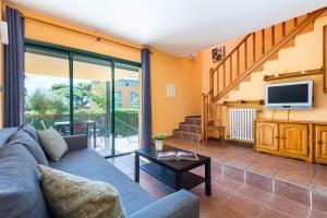 a living room with a couch and a tv at Apartamentos Punta Prima By EscapeHome in Punta Prima