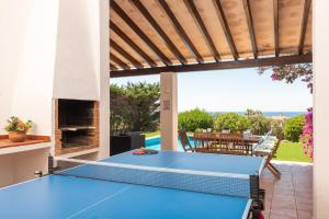 a ping pong table on the patio of a house at Villa Ribes in Binibeca