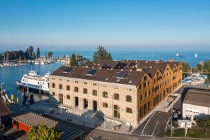 a large building next to a marina with boats at Ferien im Kornhaus am Bodensee in Romanshorn
