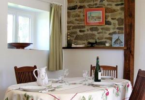 a dining room table with a bottle of wine on it at Gîte Les 3 Voiles in Ploumilliau