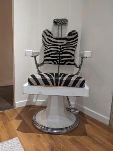 einen weißen Stuhl mit schwarzen und weißen gestreiften Kissen in der Unterkunft Appartement vintage in Avignon
