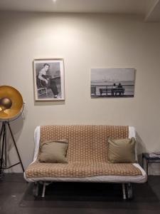 ein Sofa in einem Zimmer mit zwei Bildern an der Wand in der Unterkunft Appartement vintage in Avignon