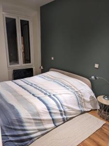ein Bett mit gestreifter Decke in einem Schlafzimmer in der Unterkunft Appartement vintage in Avignon