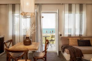 a living room with a table and a view of the ocean at Doryssa Coast Apartments in Pythagoreio