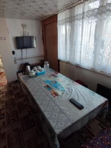 uma mesa num quarto com uma toalha de mesa em Guest house SONO adress Derbisheva 202 em Karakol
