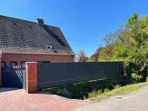 una cerca negra frente a una casa en Ferienwohnung "Nesco", en Aurich