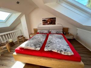 a bedroom with a red bed in a attic at Alpenliebe-mit Bergblick in Oberstaufen