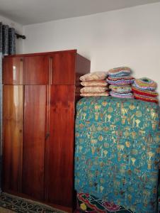 um quarto com uma cama e um armário de madeira em Guest house SONO adress Derbisheva 202 em Karakol
