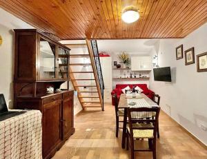 a living room with a dining room table and a staircase at Rifugio Luce in Ovindoli