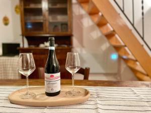 a bottle of wine and two wine glasses on a table at Rifugio Luce in Ovindoli