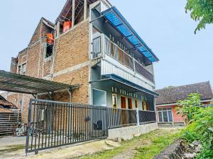 a brick building with a staircase on top of it at OYO 92168 Kost Pak Suyatno Syariah in Ponorogo