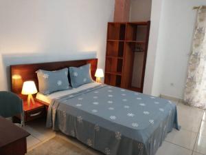 1 dormitorio con 1 cama con edredón azul en LES YILLAGA en Kribi