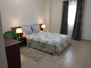 sypialnia z łóżkiem, biurkiem i 2 lampami w obiekcie LES YILLAGA w mieście Kribi