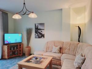 ein Wohnzimmer mit einem Sofa und einem TV in der Unterkunft Appartementhaus Villa Josephine in Kühlungsborn