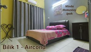 a bedroom with a bed with a pink blanket at Mieda Homestay Ipoh with WIFI in Chemor