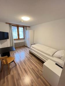 um quarto com uma cama e uma televisão em Hotel Drei Könige em Chur