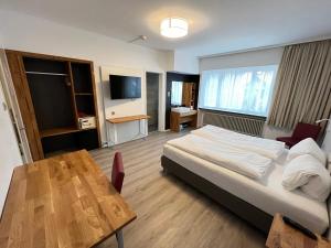 um quarto com uma cama, uma mesa e uma televisão em Hotel Drei Könige em Chur