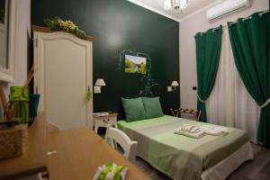 sypialnia z 2 łóżkami i zieloną ścianą w obiekcie B&B Grazia w mieście Kapua