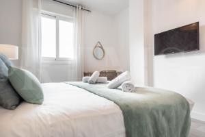 A bed or beds in a room at Stylish apartments with balcony & parking near the beach by REMS
