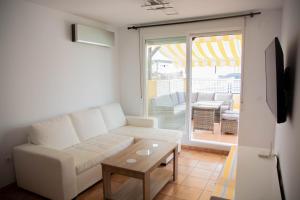 Kione Bellamar في الكوسيبري: غرفة معيشة مع أريكة بيضاء وطاولة