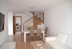 a dining room with a white table and a white couch at Kione Bellamar in Alcossebre