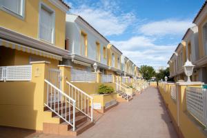een rij gele gebouwen met trappen op een stoep bij Kione Bellamar in Alcossebre