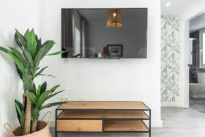A television and/or entertainment centre at Stylish apartments with balcony & parking near the beach by REMS