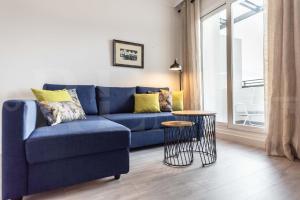 A seating area at Stylish apartments with balcony & parking near the beach by REMS