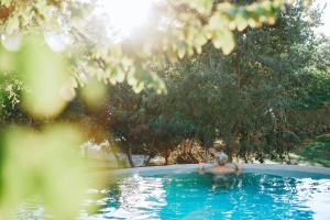 a woman is in a swimming pool at Slowness - Kibbutz Moran in Moran