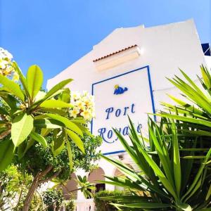 a sign on the side of a building with plants at 91 Port Royale Los Cristianos in Los Cristianos