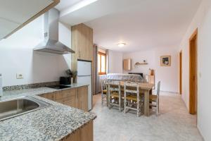 eine Küche und ein Esszimmer mit einem Tisch und Stühlen in der Unterkunft Apartamentos Vicenta in Valdelinares