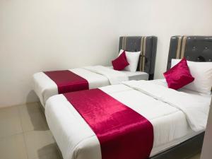 2 Betten nebeneinander in einem Zimmer in der Unterkunft Hiast Syariah Residence in Palembang