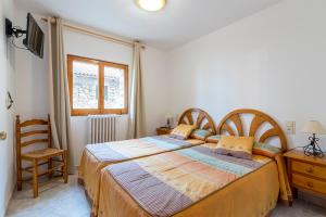 a bedroom with a bed and a desk and a chair at Apartamentos Vicenta in Valdelinares